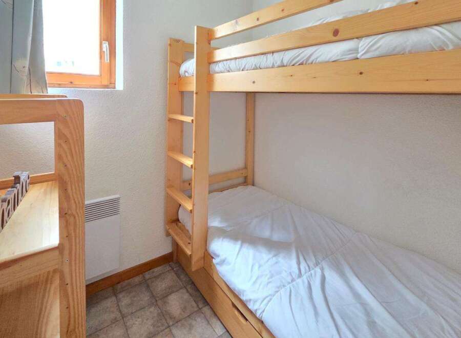 This cozy bedroom features a space-saving bunk bed, perfect for families or accommodating guests.