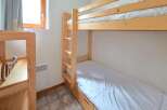 This cozy bedroom features a space-saving bunk bed, perfect for families or accommodating guests.
