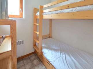 This cozy bedroom features a space-saving bunk bed, perfect for families or accommodating guests.