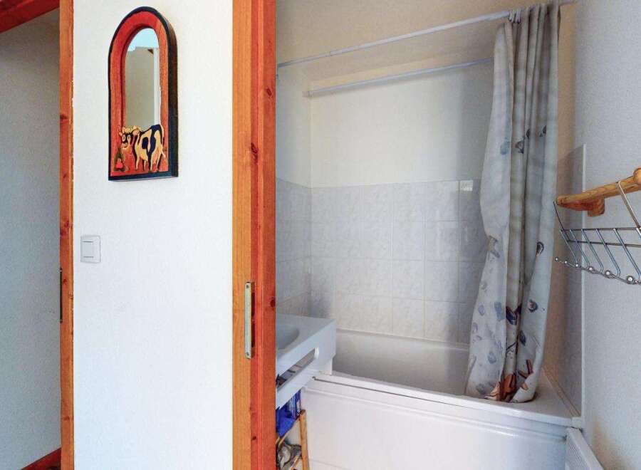 Step into this charming bathroom featuring a clean white bathtub and shower area, perfect for relaxation.