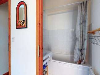 Step into this charming bathroom featuring a clean white bathtub and shower area, perfect for relaxation.