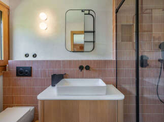 Experience modern comfort in this stylish bathroom featuring a sleek vanity with a vessel sink and a minimalist black faucet.