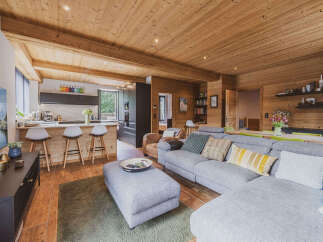 Experience luxury mountain living in this stunning open-concept home featuring a modern kitchen with a breakfast bar and a spacious living area perfect for gatherings.
