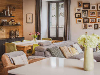 This inviting living and dining area features a warm wooden accent wall, complemented by a spacious dining table and comfortable seating.
