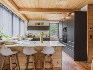 Experience modern mountain living in this stunning kitchen featuring sleek, dark cabinetry and a spacious island with bar seating.