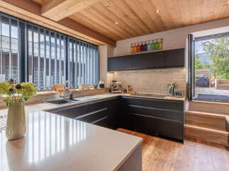 Experience modern living in this stunning kitchen featuring sleek dark cabinetry and a spacious quartz countertop.