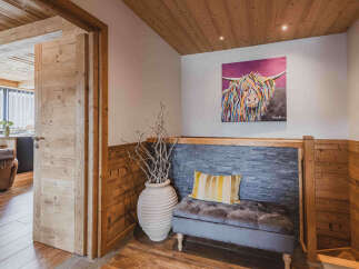 Experience rustic charm in this inviting entryway, featuring warm wooden paneling and a cozy seating area.