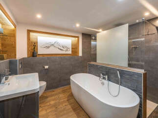 Experience luxury in this modern bathroom featuring a freestanding soaking tub and a spacious walk-in shower with sleek glass enclosure.