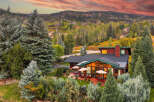 Experience luxurious mountain living in this stunning home nestled amidst a vibrant autumn landscape.