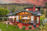 Experience luxury mountain living with this stunning property featuring a spacious patio perfect for entertaining, complete with a grill and outdoor dining sets.