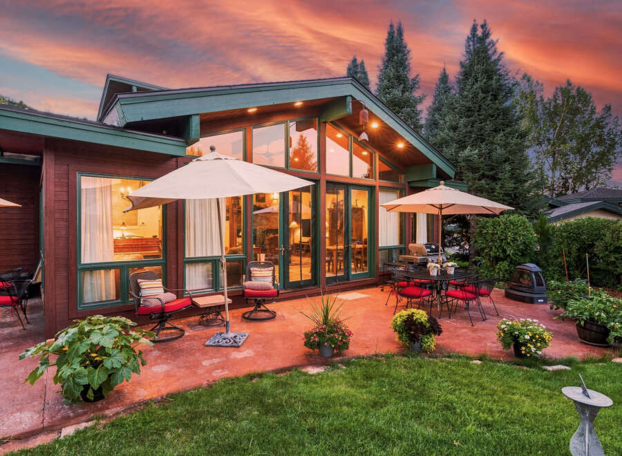 Experience luxurious outdoor living with this stunning patio featuring comfortable seating, a dining set, and a grill, perfect for entertaining.