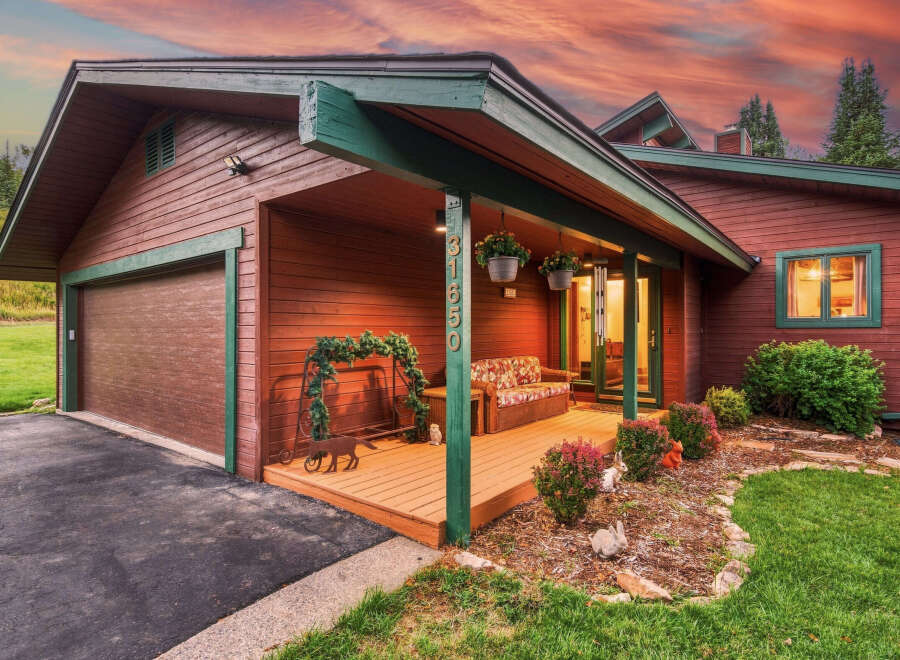 Charming wooden home with a welcoming porch, perfect for enjoying the serene surroundings.