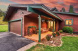 Charming wooden home with a welcoming porch, perfect for enjoying the serene surroundings.