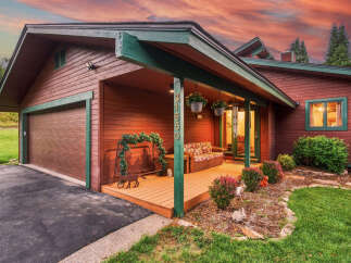 Charming wooden home with a welcoming porch, perfect for enjoying the serene surroundings.