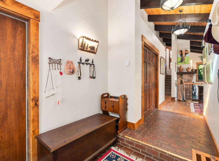 Step into a warm and inviting entryway featuring rustic wooden doors and a charming bench for seating.