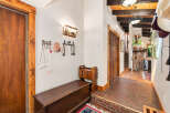 Step into a warm and inviting entryway featuring rustic wooden doors and a charming bench for seating.