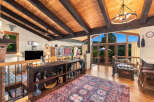 Experience rustic charm and breathtaking views in this stunning living space, featuring a vaulted wood-beam ceiling and expansive windows that flood the room with natural light.