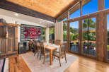 Experience breathtaking mountain views from this stunning dining room, featuring a vaulted wood-beamed ceiling and expansive windows that flood the space with natural light.