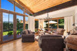 Experience breathtaking mountain views from this stunning living room, featuring soaring vaulted ceilings with exposed wood beams and expansive windows that flood the space with natural light.