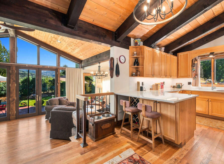 Experience breathtaking mountain views from this stunning home featuring a vaulted wood-beamed ceiling and expansive windows.