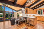 Experience breathtaking mountain views from this stunning home featuring a vaulted wood-beamed ceiling and expansive windows.