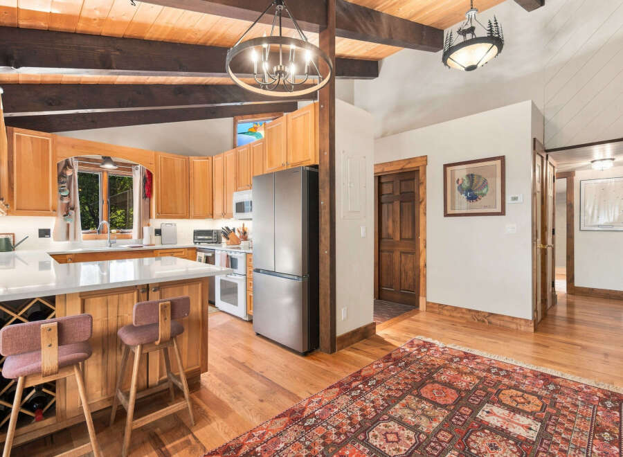 Experience rustic charm in this inviting kitchen and dining area, featuring warm wood cabinetry, a spacious island with wine storage, and a cozy breakfast bar.