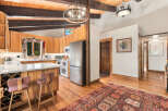 Experience rustic charm in this inviting kitchen and dining area, featuring warm wood cabinetry, a spacious island with wine storage, and a cozy breakfast bar.