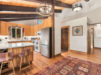 Experience rustic charm in this inviting kitchen and dining area, featuring warm wood cabinetry, a spacious island with wine storage, and a cozy breakfast bar.
