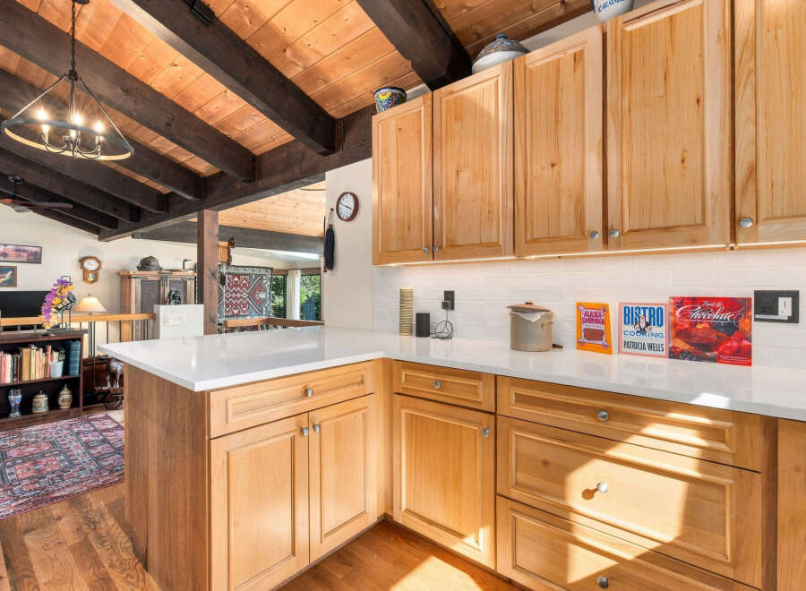 Experience rustic charm in this beautifully appointed kitchen, featuring warm, natural wood cabinetry and exposed beamed ceilings.