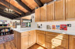 Experience rustic charm in this beautifully appointed kitchen, featuring warm, natural wood cabinetry and exposed beamed ceilings.