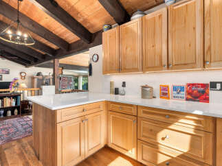 Experience rustic charm in this beautifully appointed kitchen, featuring warm, natural wood cabinetry and exposed beamed ceilings.