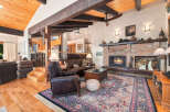 Experience rustic charm in this spacious living room featuring a grand brick fireplace and exposed wooden beams.