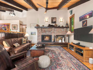 Experience rustic charm in this inviting living room, featuring a grand brick fireplace as the centerpiece.