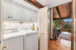 Discover a functional laundry area featuring white cabinetry and appliances, perfect for keeping chores organized.