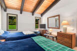 This charming bedroom features two comfortable beds dressed in deep blue linens, perfect for a restful night's sleep.