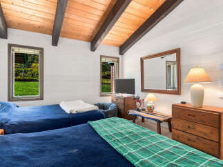 This charming bedroom features two comfortable beds dressed in deep blue linens, perfect for a restful night's sleep.