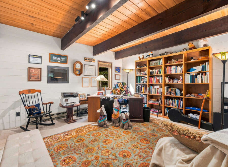 This cozy home office features a warm wooden ceiling with exposed beams, creating a rustic yet inviting atmosphere.