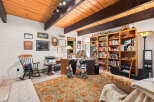 This cozy home office features a warm wooden ceiling with exposed beams, creating a rustic yet inviting atmosphere.