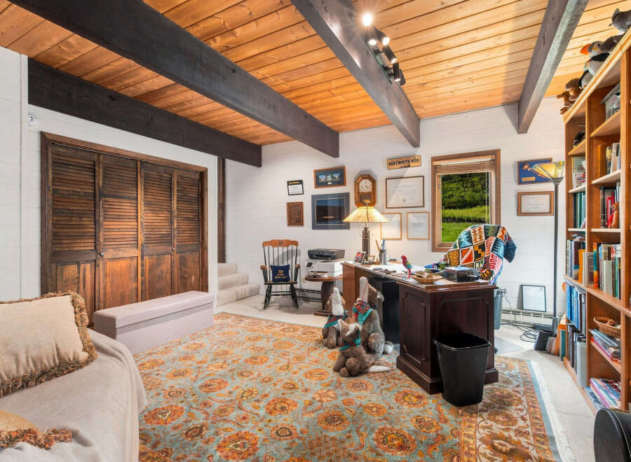 Discover this charming home office featuring a rustic wooden ceiling with exposed beams, creating a warm and inviting atmosphere.