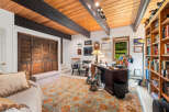Discover this charming home office featuring a rustic wooden ceiling with exposed beams, creating a warm and inviting atmosphere.