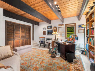 Discover this charming home office featuring a rustic wooden ceiling with exposed beams, creating a warm and inviting atmosphere.