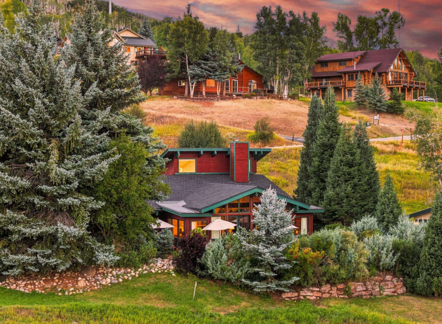 Nestled amidst lush greenery and mature trees, this stunning mountain home offers breathtaking views and a serene escape.