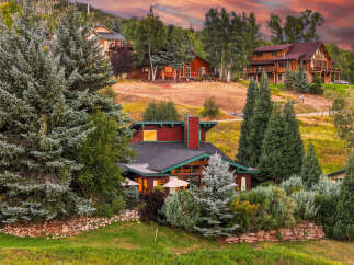 Nestled amidst lush greenery and mature trees, this stunning mountain home offers breathtaking views and a serene escape.