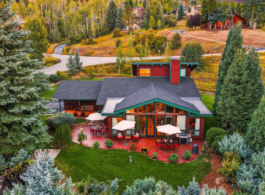 Experience luxury mountain living in this stunning home, nestled amidst vibrant autumn foliage and mature evergreen trees.