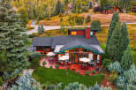 Experience luxury mountain living in this stunning home, nestled amidst vibrant autumn foliage and mature evergreen trees.