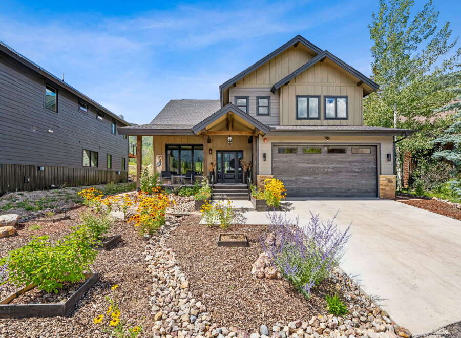 Discover this stunning modern mountain home featuring a welcoming covered porch and a spacious two-car garage.