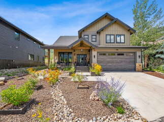Discover this stunning modern mountain home featuring a welcoming covered porch and a spacious two-car garage.