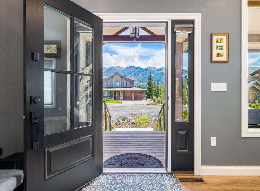 Step into this stunning mountain home through a grand, open-concept entryway that offers breathtaking views of the surrounding peaks.