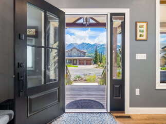 Step into this stunning mountain home through a grand, open-concept entryway that offers breathtaking views of the surrounding peaks.