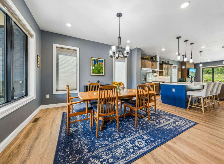 This spacious dining area features a large wooden table with six chairs, perfect for family gatherings.